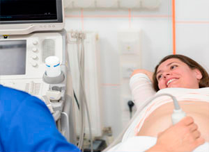 Técnico realizando una ecografía en el abdomen de una paciente